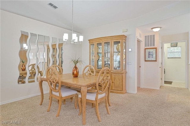 dining room featuring light colored carpet and an inviting chandelier