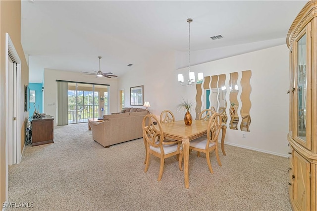 dining room featuring ceiling fan with notable chandelier, lofted ceiling, and light carpet