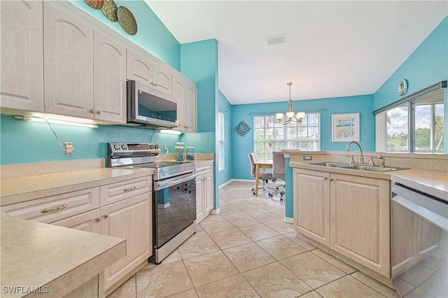 kitchen with stainless steel appliances, an inviting chandelier, lofted ceiling, a wealth of natural light, and pendant lighting