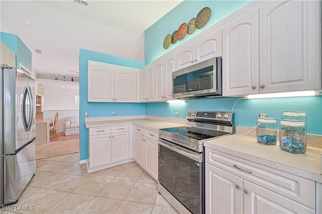 kitchen with white cabinets, appliances with stainless steel finishes, and light tile patterned floors