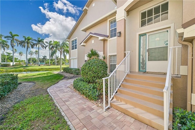 doorway to property with a lawn