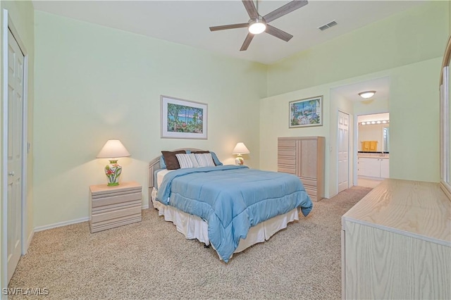 carpeted bedroom featuring ceiling fan and ensuite bath