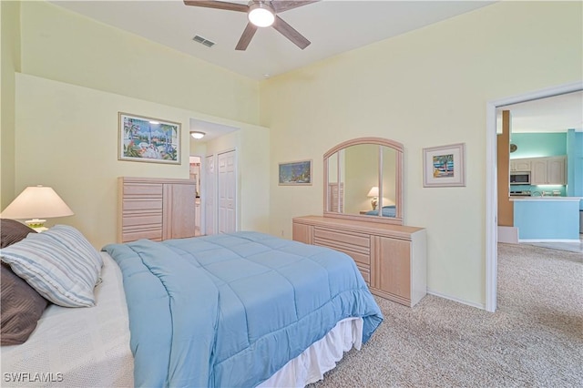 bedroom with ceiling fan, a closet, and light carpet