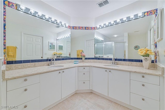 bathroom with tile patterned flooring, an enclosed shower, and vanity