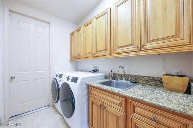 washroom featuring cabinets, sink, and washing machine and dryer