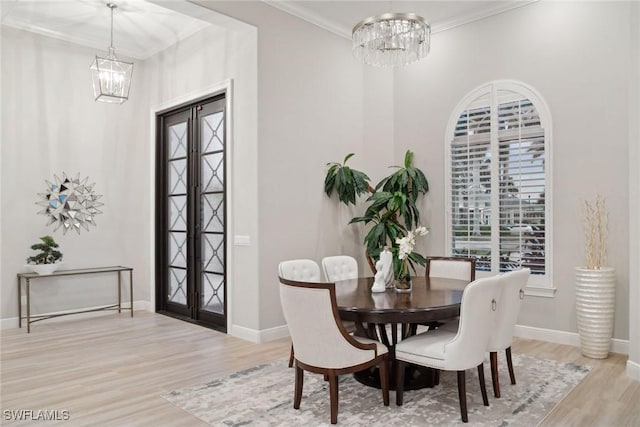 dining area featuring an inviting chandelier, light hardwood / wood-style floors, and french doors