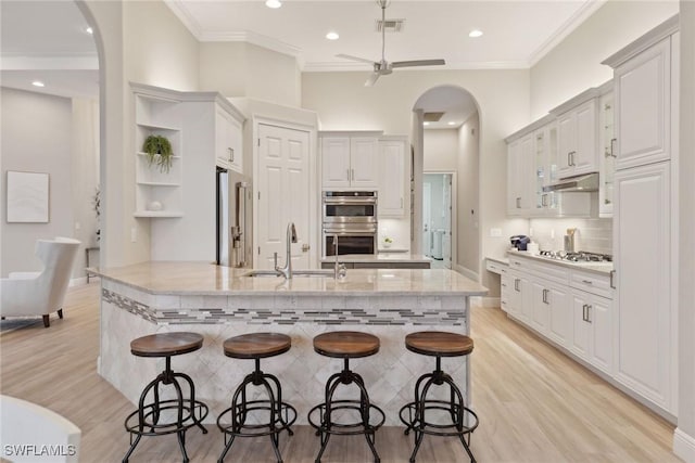 kitchen with white cabinets, a breakfast bar, appliances with stainless steel finishes, and sink