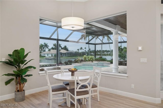 dining room featuring a water view and light wood-type flooring