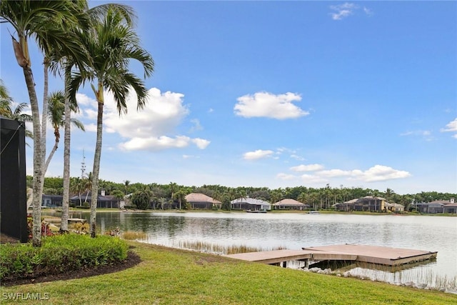 view of dock featuring a lawn and a water view