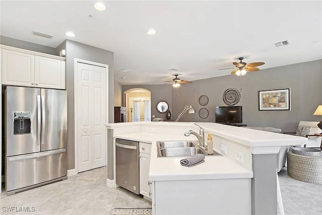 kitchen with white cabinets, a kitchen island with sink, sink, and stainless steel appliances