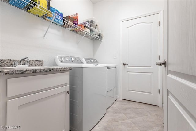 laundry room with washer and dryer and cabinets