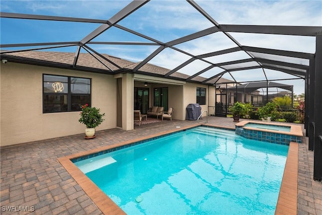 view of pool featuring glass enclosure, an in ground hot tub, an outdoor hangout area, a patio, and grilling area