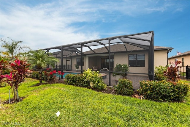 back of house featuring a lawn and glass enclosure