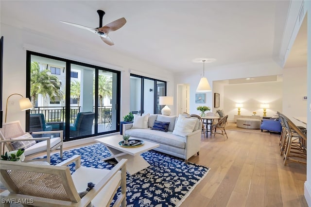 living room with light wood-type flooring and ceiling fan