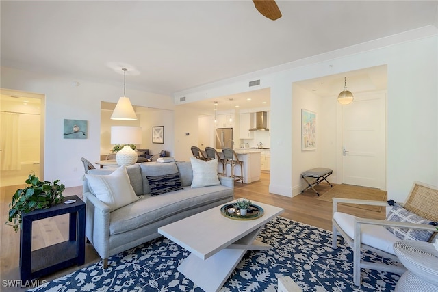 living room with light wood-type flooring and ceiling fan