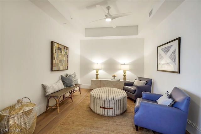 sitting room with ceiling fan and hardwood / wood-style flooring