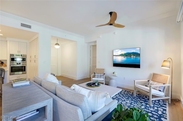 living room with ceiling fan and light wood-type flooring