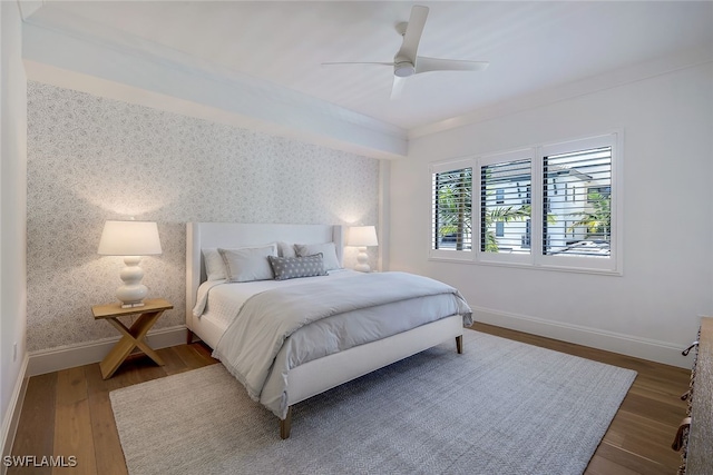 bedroom featuring ceiling fan, dark wood-type flooring, and ornamental molding