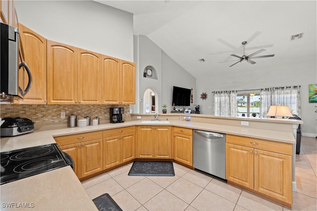 kitchen with high vaulted ceiling, kitchen peninsula, appliances with stainless steel finishes, and light tile patterned flooring