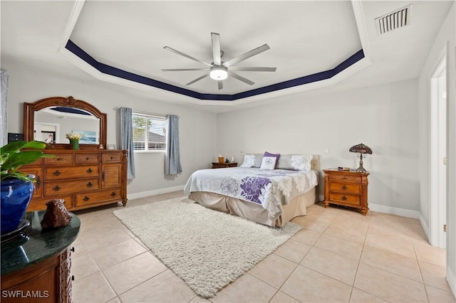 tiled bedroom featuring ceiling fan and a raised ceiling