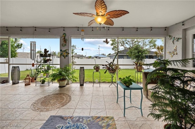 sunroom / solarium with a healthy amount of sunlight and ceiling fan