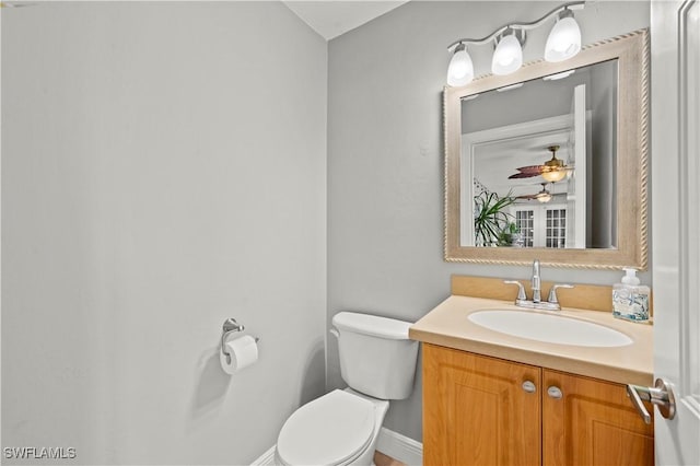 bathroom with toilet, ceiling fan, and vanity