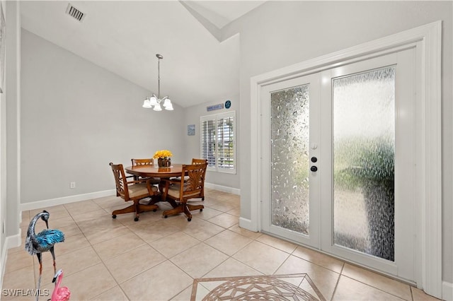 dining area featuring light tile patterned floors, vaulted ceiling, a notable chandelier, and french doors