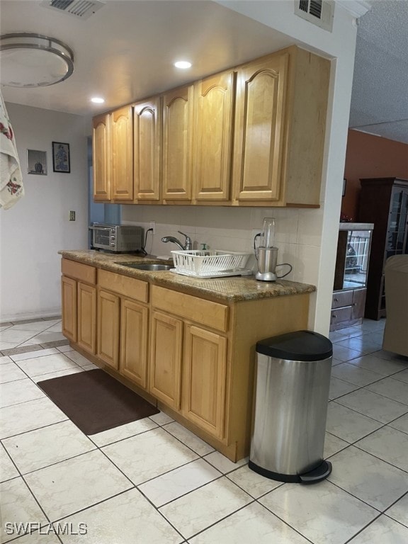 kitchen with sink, backsplash, and light tile patterned floors