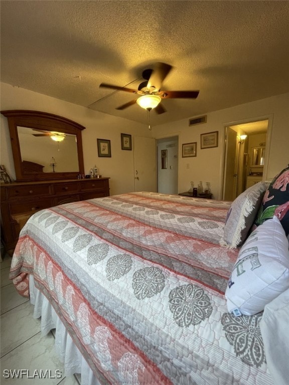 bedroom with ceiling fan and a textured ceiling