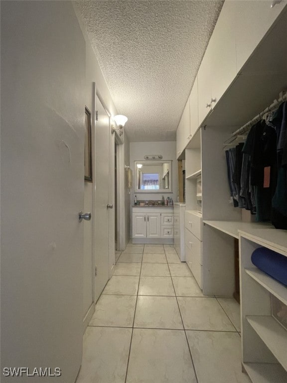 bathroom with a textured ceiling, tile patterned floors, and vanity