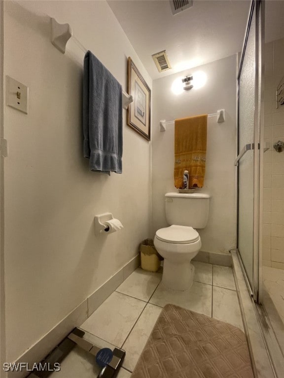 bathroom with a shower with door, tile patterned floors, and toilet