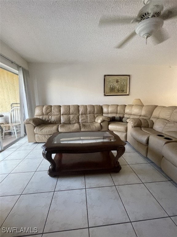 living room with a textured ceiling, ceiling fan, and light tile patterned floors