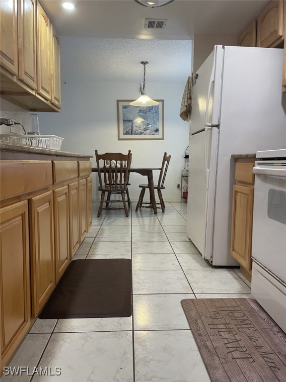 kitchen with white appliances, pendant lighting, sink, and light tile patterned floors