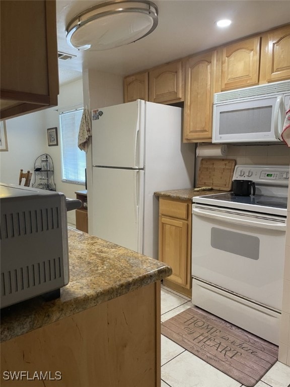 kitchen featuring white appliances, light brown cabinetry, and light tile patterned floors