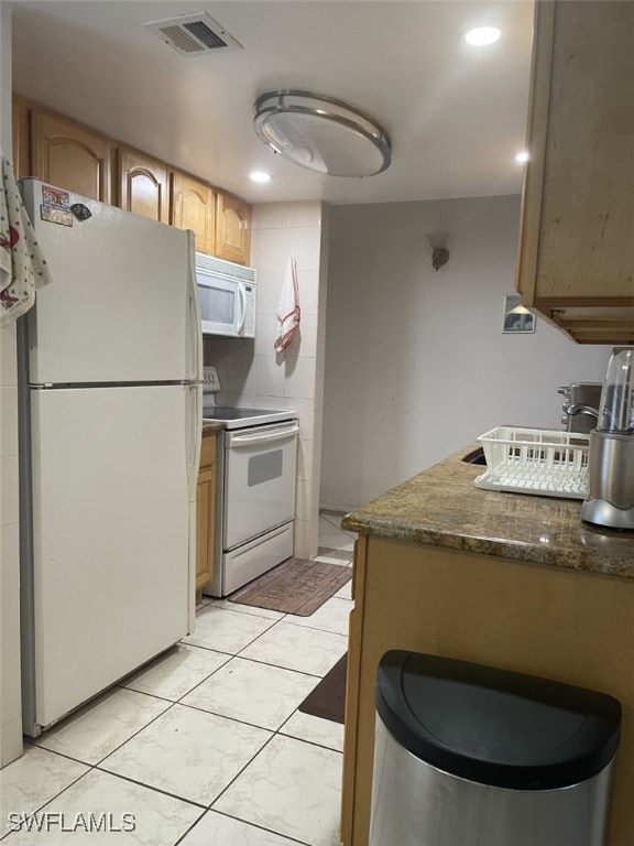 kitchen featuring white appliances and light tile patterned floors