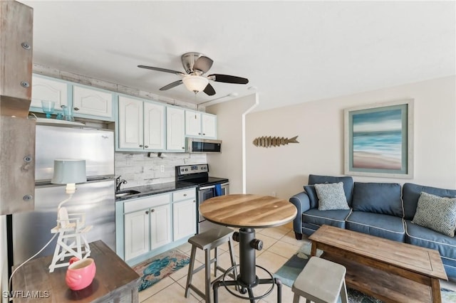 kitchen featuring light tile patterned floors, white cabinets, appliances with stainless steel finishes, and tasteful backsplash