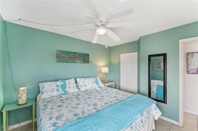 tiled bedroom featuring ceiling fan and a closet