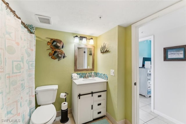 bathroom featuring toilet, vanity, and tile patterned flooring