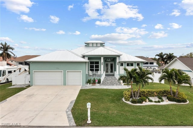 view of front of house featuring a garage, a front yard, and french doors