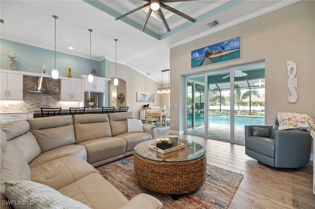 living room featuring a high ceiling, crown molding, and ceiling fan