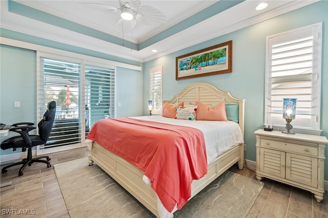 bedroom featuring crown molding, light wood-type flooring, a tray ceiling, ceiling fan, and access to exterior