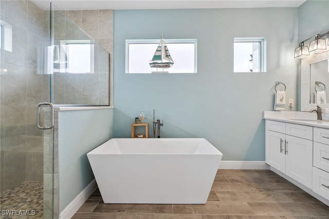 bathroom with vanity and shower with separate bathtub