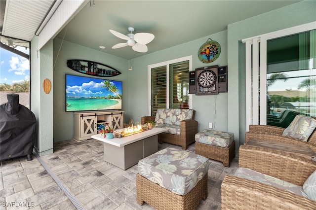 view of patio / terrace with grilling area, an outdoor living space with a fire pit, and ceiling fan