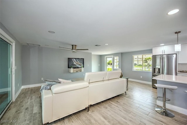 living room with ceiling fan and light hardwood / wood-style floors