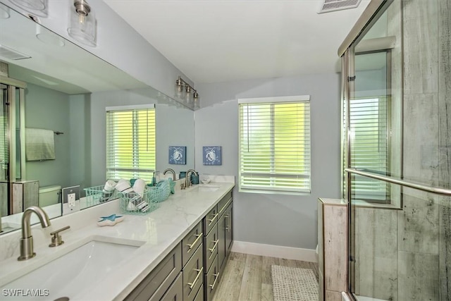 bathroom featuring a shower with door, vanity, hardwood / wood-style floors, and plenty of natural light