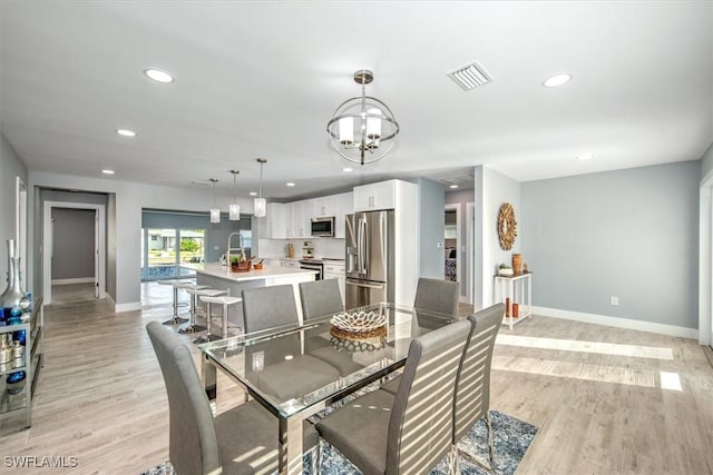 dining space featuring a chandelier and light hardwood / wood-style floors