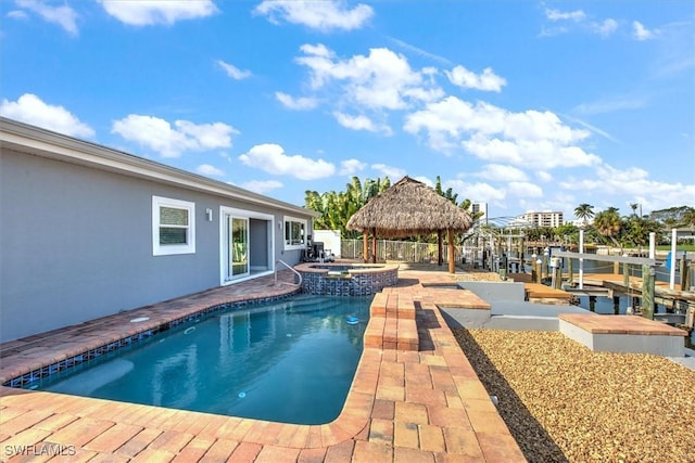 view of pool with a patio, a water view, an in ground hot tub, and a gazebo