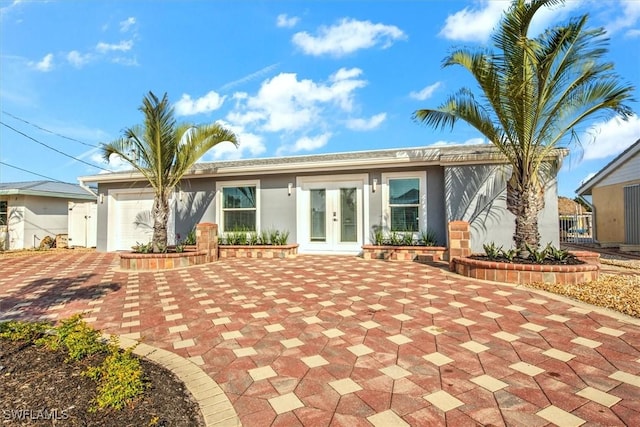 back of property with french doors and a garage