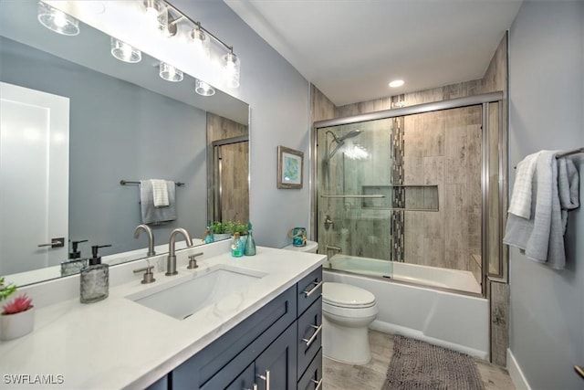 full bathroom featuring enclosed tub / shower combo, vanity, and toilet