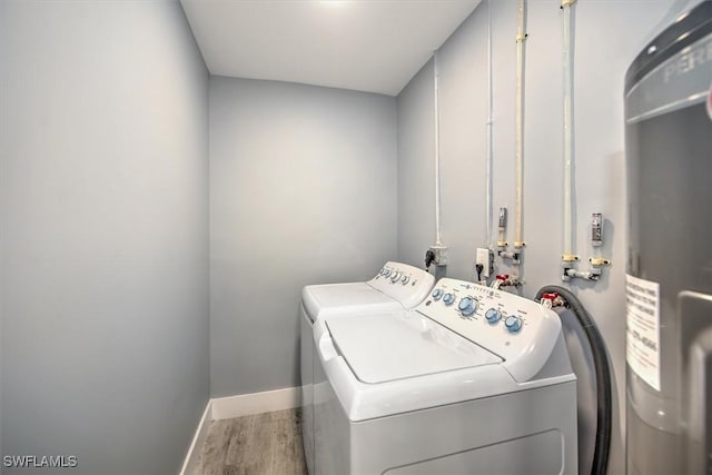 laundry area featuring washing machine and dryer, water heater, and hardwood / wood-style floors